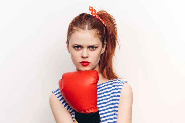 Mujer en guantes de boxeo rojo sobre un fondo claro modelo de emociones de agresión — Foto de Stock