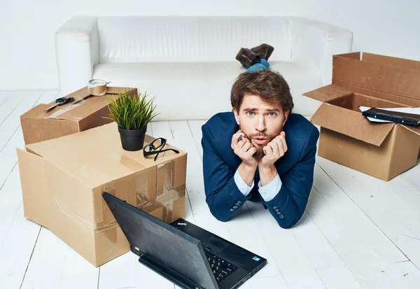 Un homme se trouve devant un ordinateur portable boîtes avec des choses déballer Office professionnel — Photo