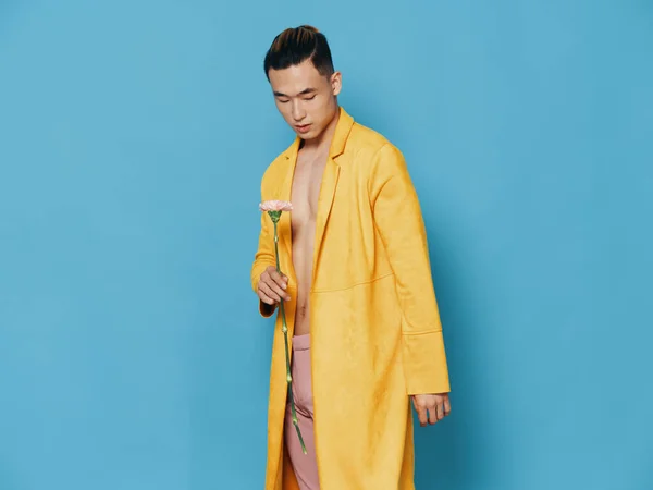 Homem romântico com flor e casaco amarelo torso nu modelo de fundo azul — Fotografia de Stock