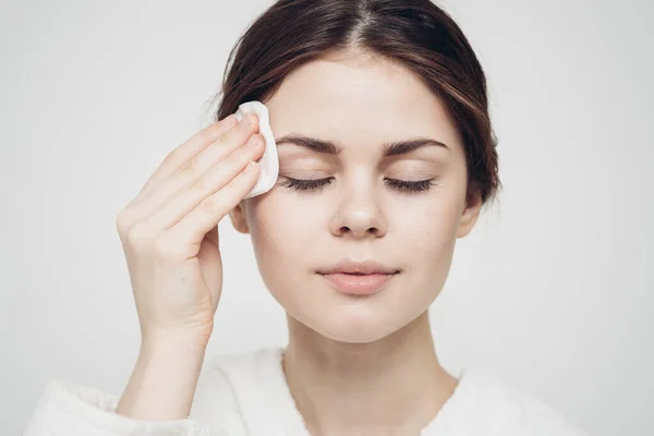 Vrouw veegt haar gezicht met een witte zachte spons schoonheid zorg model — Stockfoto