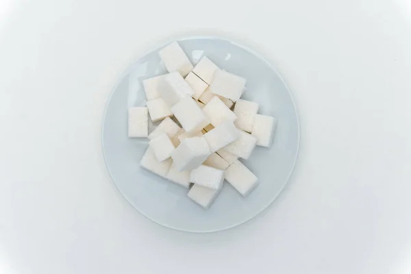 Granulated sugar cubes on a plate sweets light background — Stock Photo, Image