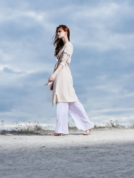 Retrato de una mujer en ropa ligera Nubes en el fondo arena naturaleza vista inferior —  Fotos de Stock