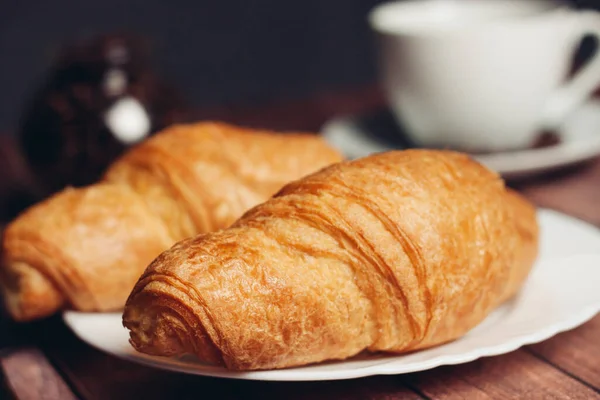 Croissanter i tallrik på bordsmjöl dessert kaffe — Stockfoto