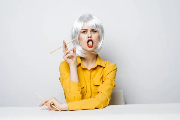 Mujer en peluca blanca rollos de sushi comida dietética palillos — Foto de Stock