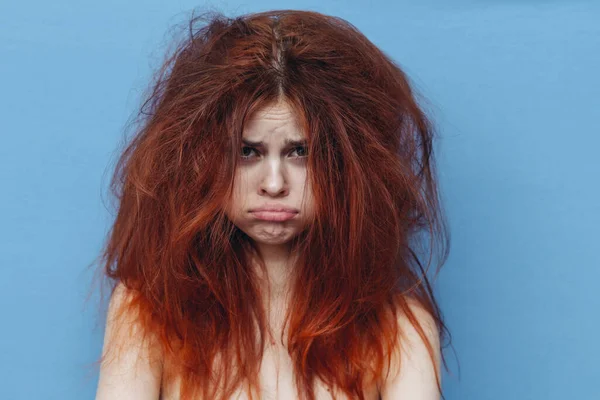 Rothaarige Frau mit wirren Haaren auf dem Kopf auf blauem Hintergrund abgeschnitten Ansicht — Stockfoto