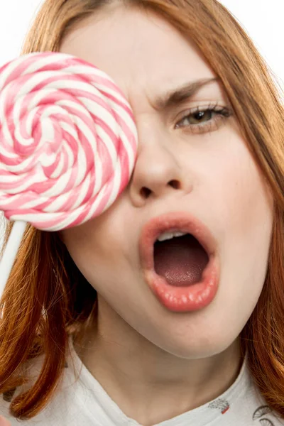 Веселая красивая женщина с леденцом у лица сладости десерт — стоковое фото