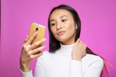 Pembe arka plan görüntülü güzel bir Asyalı kadın.