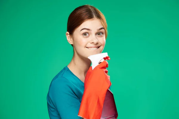 Красивая женщина с зеленым фоном уборки моющих средств — стоковое фото