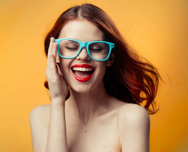 Attractive woman naked shoulders red lips blue glasses studio — Stock Photo, Image