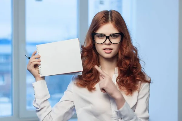 Руда жінка в окулярах з блокнотом в руках офіційний менеджер — стокове фото