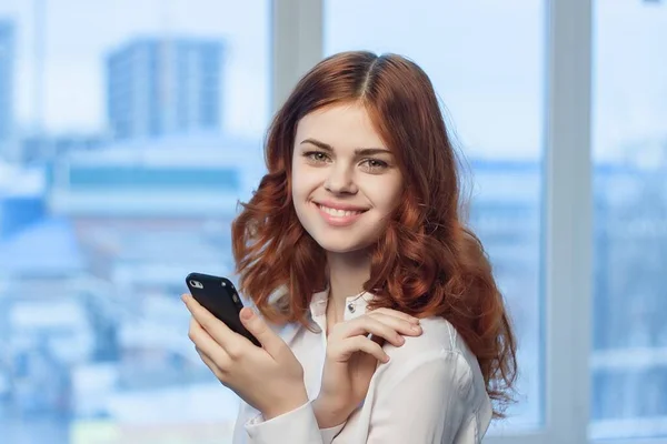 Frau im Hemd mit Handy in der Hand — Stockfoto