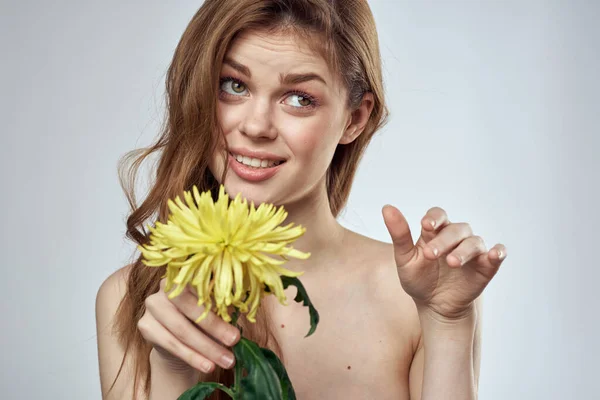 Portrait d'une belle femme avec une fleur jaune sur un fond clair recadré d'espace de copie Modèle — Photo