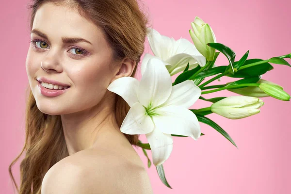 Retrato de una hermosa mujer con flores blancas en sus manos sobre un fondo rosa Copiar Espacio vista recortada — Foto de Stock