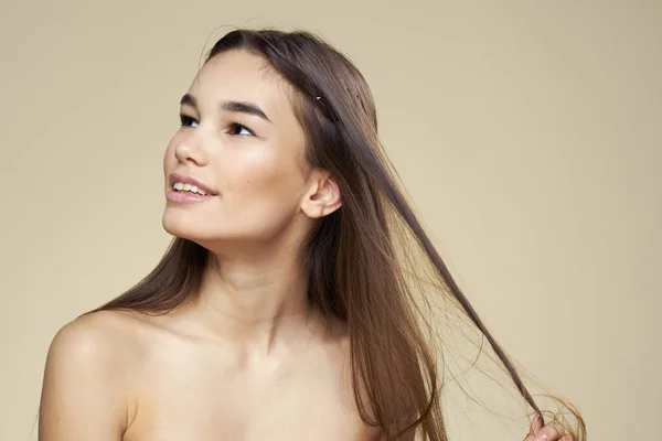 Hübsche Frau nackte Schultern Kosmetik saubere Haut Haarpflege beige Hintergrund — Stockfoto