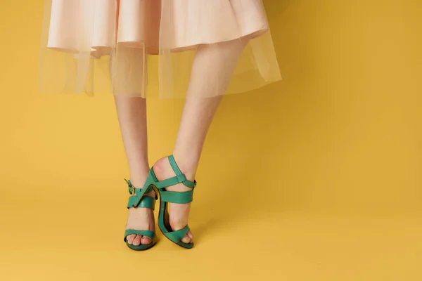 Sapatos de moda sapatos verdes pés femininos compras fundo amarelo — Fotografia de Stock