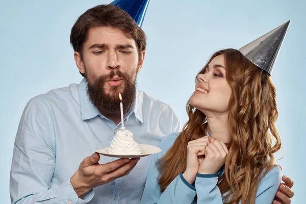 Веселые мужчина и женщина с тортом в тарелке корпоративной партии синий фон — стоковое фото