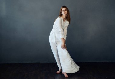 Güzel, alımlı, zarif, beyaz elbiseli bir kadın.