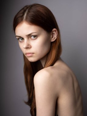 Gri arka planda güzel bir kadın. Manken kızıl saçlı. Yakın plan.