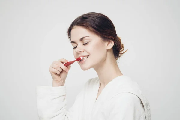 Mulher alegre em roupão escova de dentes manhã atendimento odontológico — Fotografia de Stock