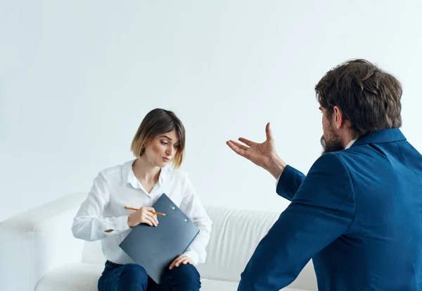 Hombre de negocios en un traje clásico y una mujer en el sofá con documentos en manos de un psicólogo — Foto de Stock