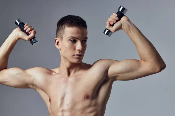 Sportig man med hantlar i händerna beskärd utsikt över biceps träning — Stockfoto