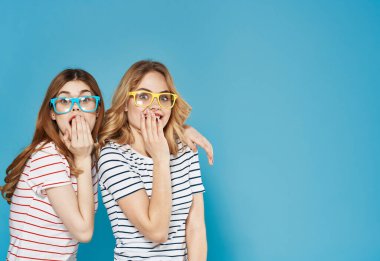 Çok renkli gözlüklü asılmış kız kardeşler çizgili tişörtler. Kopya Boşluğu ile kesilmiş duygular.