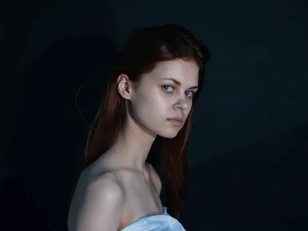 Mulher com um olhar interessado em um modelo de vista lateral de fundo escuro — Fotografia de Stock