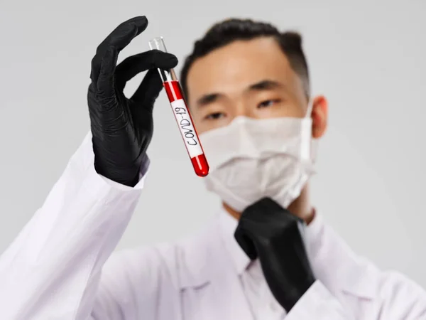 Чоловічі лабораторні техніки чорні рукавички дослідження медичної маски аналіз крові крупним планом wovid-19 — стокове фото