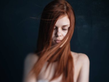 Koyu bir geçmişi olan çıplak omuzlu bir kadın. Temiz cilt kozmetoloji modeli.