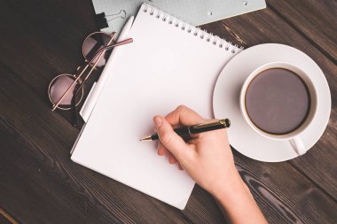 Ahşap masa üzerindeki kalemli defter kahve fincanı ofis finansmanı