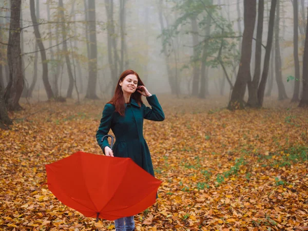 Femme avec parapluie rouge dans le parc en automne Feuilles jaunes marcher le brouillard — Photo