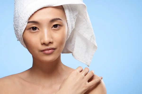 Kvinna asiatisk utseende nakna axlar klar hud hälsa blå bakgrund — Stockfoto