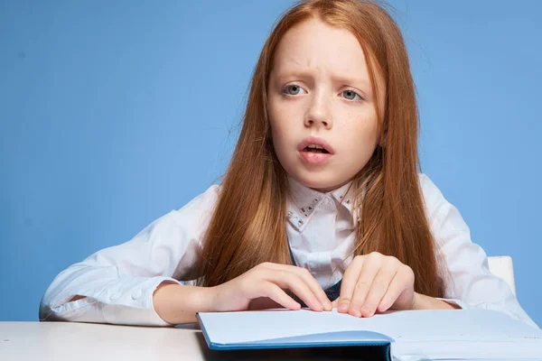 家庭教育で宿題をしている赤髪の女の子は — ストック写真