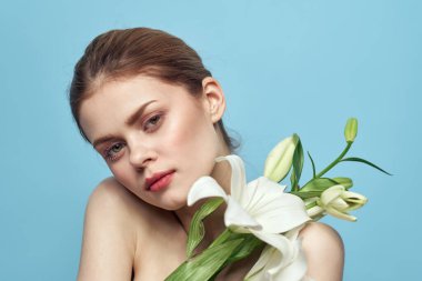 Mavi arka planda beyaz çiçekli bir kadın çıplak omuzları kesiyordu.