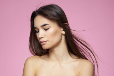 Esmer, çıplak omuzlar, temiz cilt bakımı pembe arka plan.
