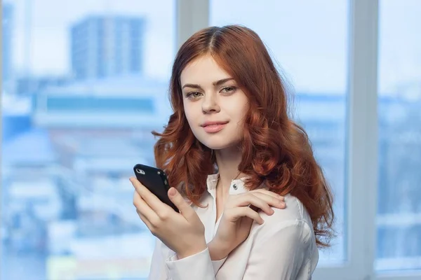 Tişörtlü kadın, elinde telefon, profesyonel. — Stok fotoğraf