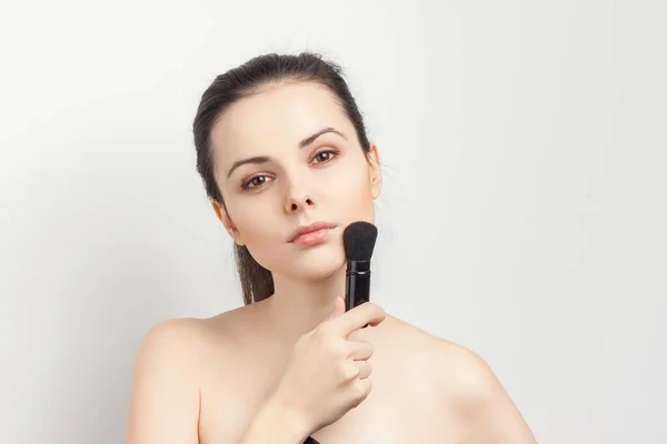 stock image brunette with bare shoulders brush in hand skin care procedures