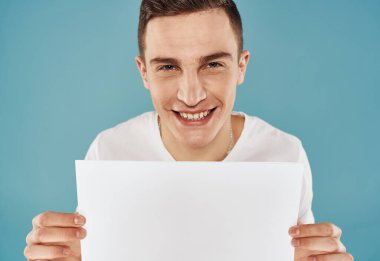 Elinde el ilanı olan adam Poster modeli mavi arka plan kırpılmış görünüm