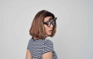 Çizgili tişörtlü neşeli kadın. Çift gözlüklü gülümseme.