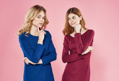 Elbiseli iki zarif kadın. Moda mankeni. Lüks pembe arka plan.