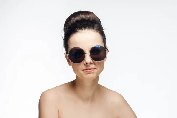 Ziemlich brünett nackte Schultern Sonnenbrille klare Haut hellen Hintergrund — Stockfoto