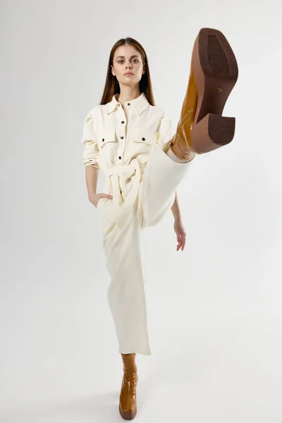 다리를 들고 현대적 인 옷을 입고 있는 유행하는 여성 이 손을 잡고 있다 — 스톡 사진