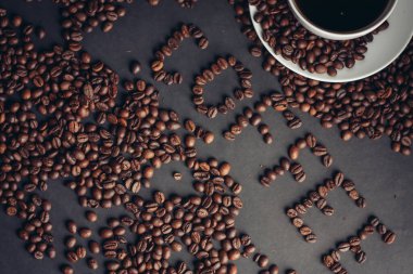 aromatik kahve çekirdekleri ve bir bardak gri arka plan görünümlü içecek.