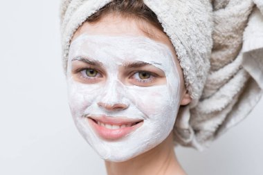 Yüzünde siyah noktalar olan beyaz maskeli güzel bir kadın.