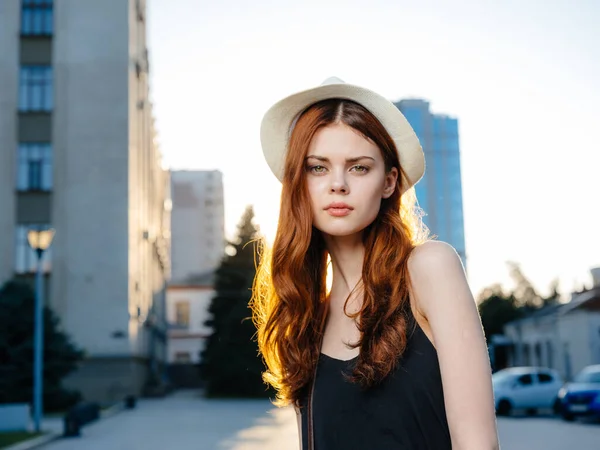 高いビルの近くの通りに帽子と黒いドレスの女性 — ストック写真