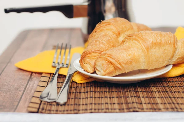 Croissanter tefat på bordet gaffel med kniv färska bakverk dessert morgon — Stockfoto