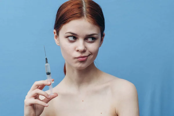 Spruta i kvinna hand på blå bakgrund injektion föryngring botox beskärd vy — Stockfoto