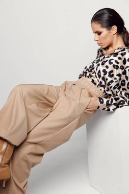 Açık arkaplanda poz veren leopar gömlekli güzel bir esmer.