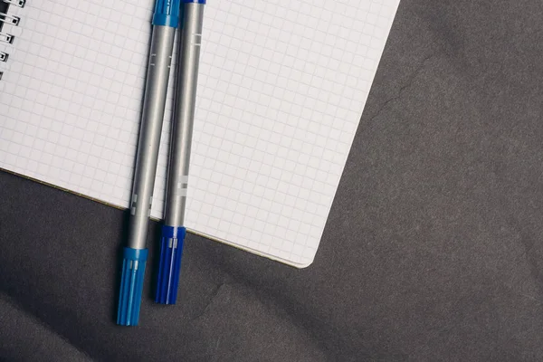Notitieblok met pennen schrijven kantoor grijze achtergrond papieren — Stockfoto