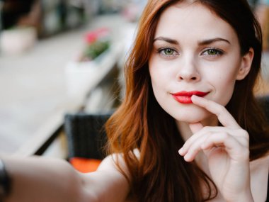 Kafede, yakın çekim makyaj modelinde, masada oturan mutlu bir kadının portresi.